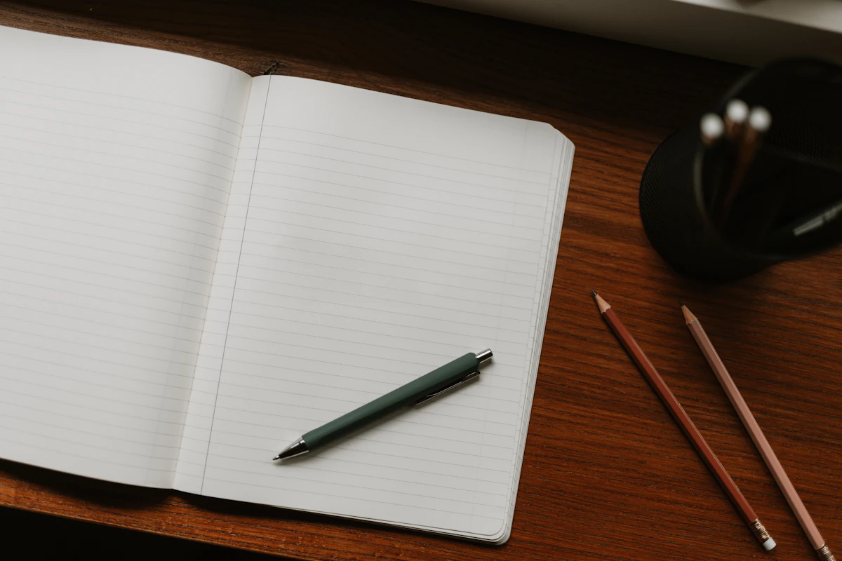 Blank notebook and pencils on a wooden desk