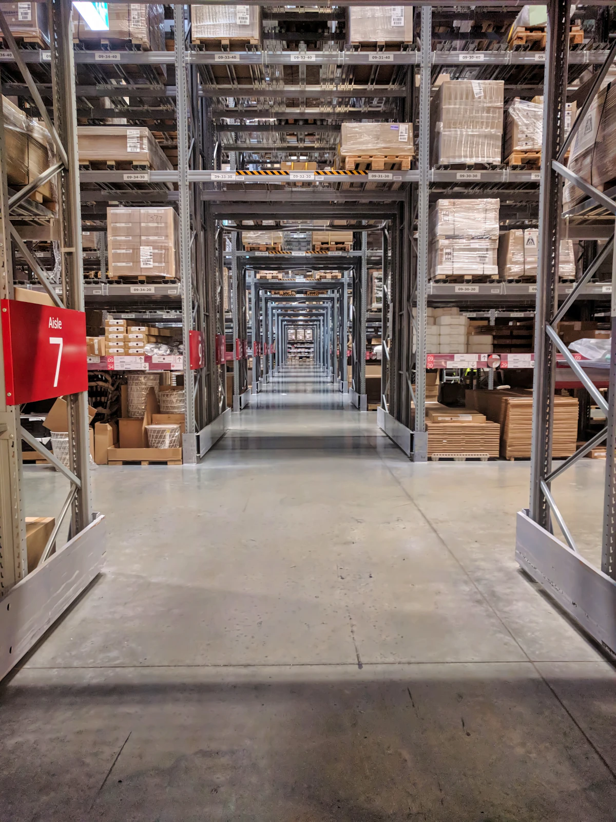 Long warehouse aisle with organized inventory shelves